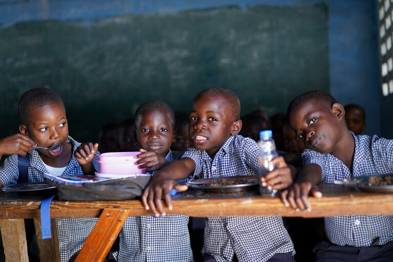 quattro bambini seduti a scuola 
